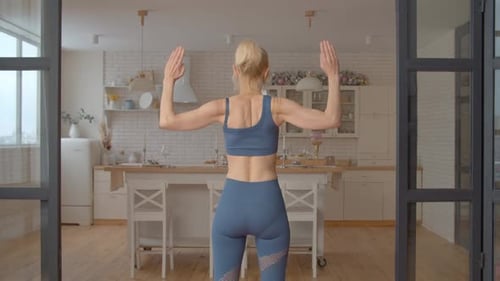 Woman Exercising in Kitchen in Workout Clothes