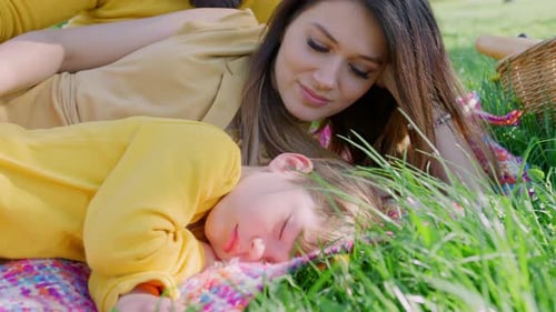 Loving Mother Cuddling Child Outdoors on Blanket