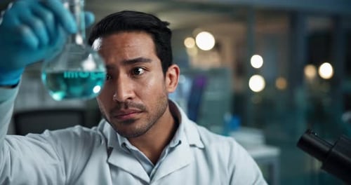 Scientist Observes Liquid and Examines Under Microscope