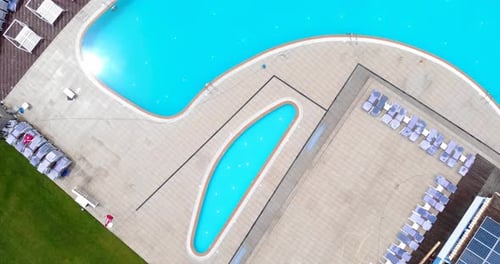 Top View Of Outdoor Swimming Pool And Lounge Chairs In A Luxury Resort. aerial drone rotate