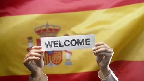 Welcome Sign in Front of Spanish Flag