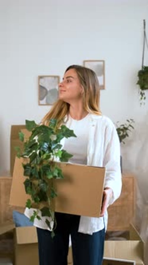 Woman Moving Home with Potted Plant
