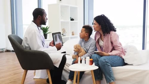 Doctor Explaining Xray to Concerned Mother and Child in Clinic