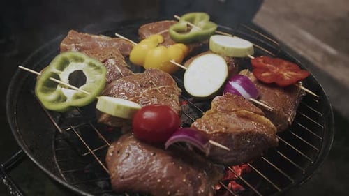 Gros plan d'une viande juteuse et appétissante, des brochettes de viande et de légumes frais sont cuits sur une grille de gril