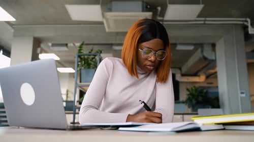African American Student Taking Notes in Library