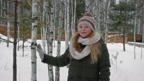 Portrait of Happy Young Caucasian Girl in Winter Clothes in Snowy Forest