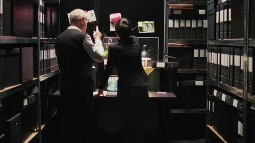 Man and Woman Investigating Documents in Archives