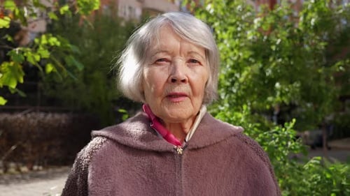 Closeup of the Face of an Old Grandmother with Gray Hair in the Park