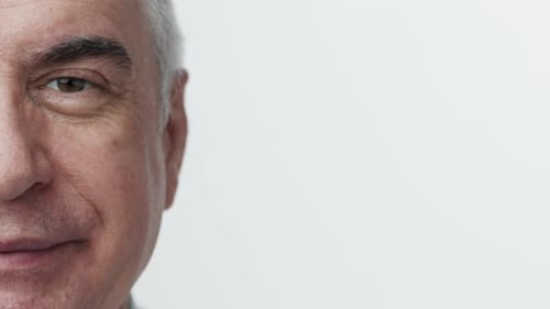 Handsome elderly man with positive expression and charming smile close up