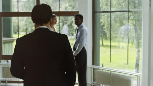 Brokers Greeting Each Other by Handshakes during Meeting at Business Center