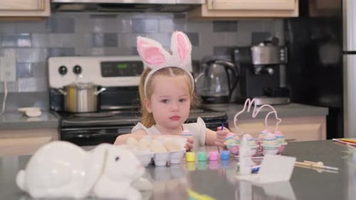 Cute Girl Painting Colorful Easter Eggs at Home