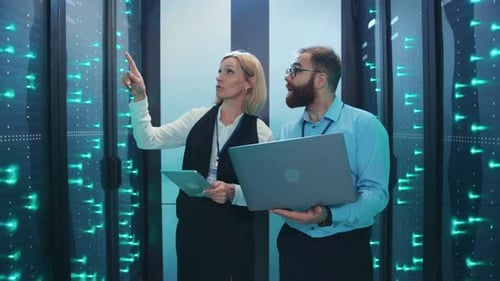 Two Professionals Manage Data Servers in Modern Room