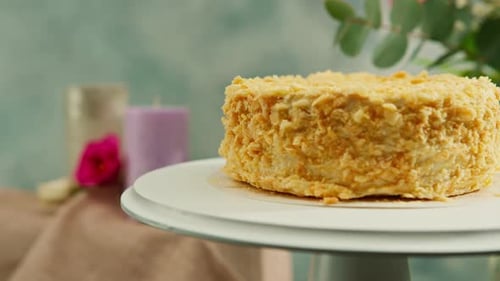 Freshly made delicious puff pastry napoleon cake on a white rotating stand against the background