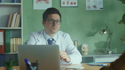 Doctor consulting patient in office, taking notes