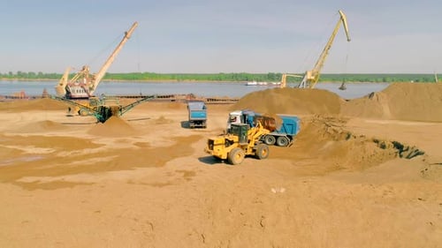 Excavator Trucks and Cranes Working at the Construction Site