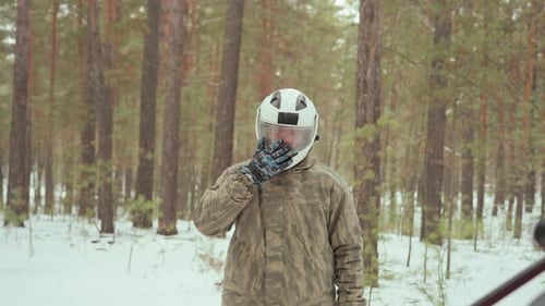 Man Prepares Vehicle Individual Inspects ATV Amidst Winter Woods Outdoor Enthusiast Prepares Red ATV