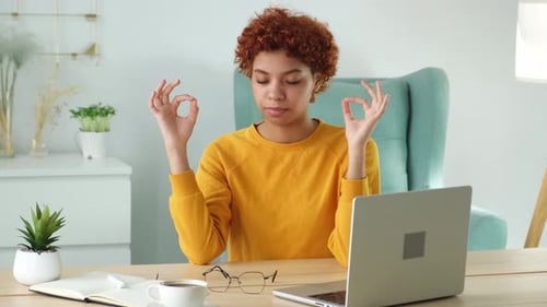 Woman Meditating at Desk with Laptop and Coffee