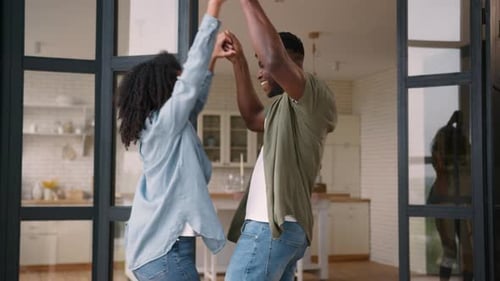 Young Couple Smiling and Dancing in Home