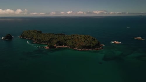 Boat driving around deserted tropical island