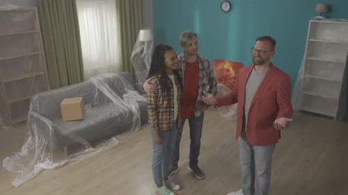 The Realtor Tells and Shows a Couple of Young People Apartments African American Woman Shaking Hands