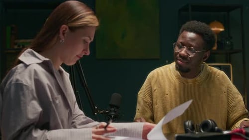 Diverse Podcast Hosts Discussing Script before Recording in Studio