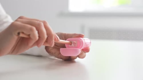 Hand Using Pink Pencil Sharpener at Desk