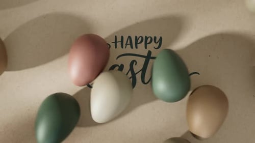 Happy Easter Calligraphy Text with Rolling Eggs Animation