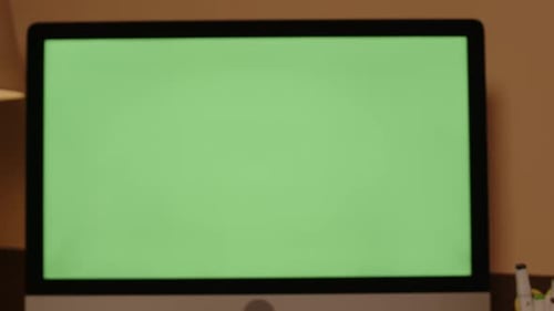 Computer Monitor with Green Screen at Work Desk in Home Office