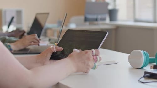 Hands of College Girl Scrolling through Source Code on Tablet