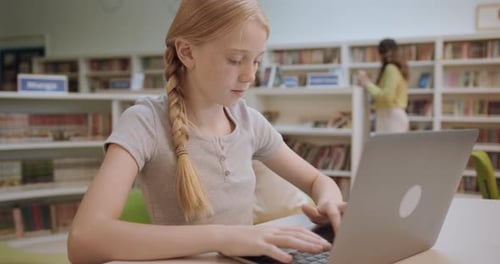 School Child Studying in Education Library using Laptop Technology