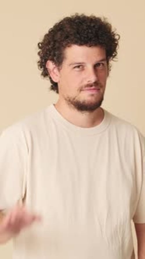 Happy man showing ok gesture isolated on beige background in studio