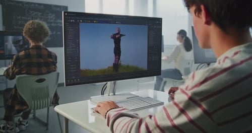 Menino na sala de aula trabalha em projeto de modelagem 3D no computador