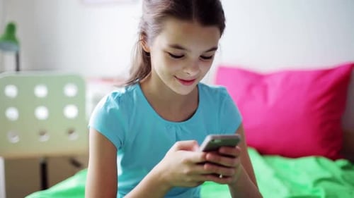 Girl Using Smartphone Sitting on Green Bed