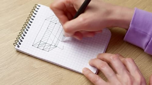 Hand drawing a technical sketch on graph paper. Concept of redesign, engineering development