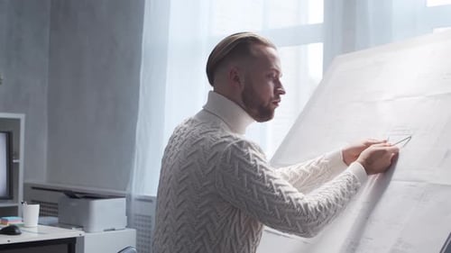 Concentrated Architect Works in Loft Using Drawing Board Workplace of Young Engineer in Modern