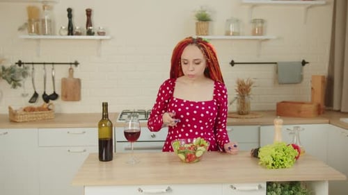 Woman Enjoys Salad and Wine in Kitchen