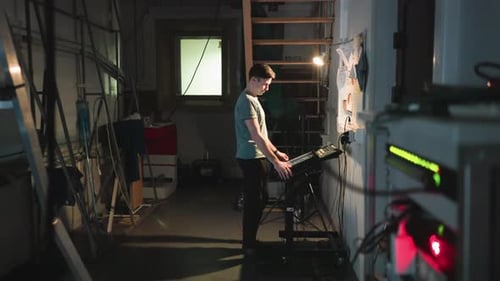 Man Operating Touchscreen Console in Industrial Studio with Technical Setup