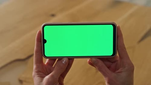 Greenscreen phone close up of anonymous businesswoman hands watching template at office