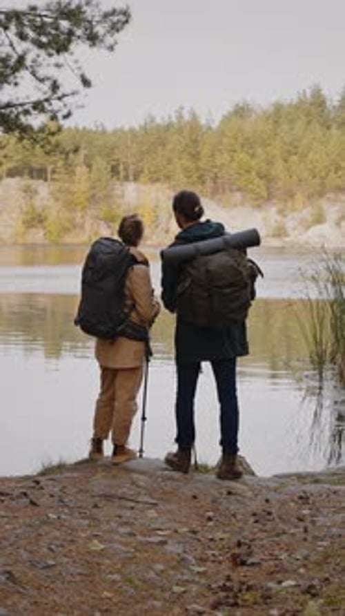 Couple Hiking with Backpacks Stands by Lake