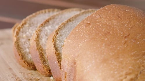 Freshly Baked Homemade White Bread with Slices on Wooden Chopping Board Outside in Natural Morning.