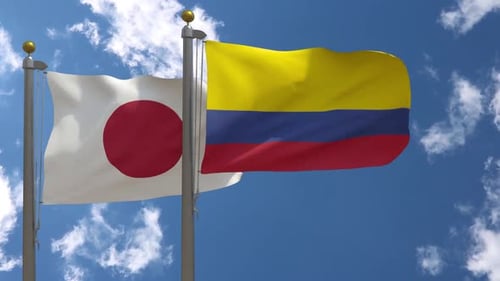 Japan and Colombia Flags Waving in Blue Sky