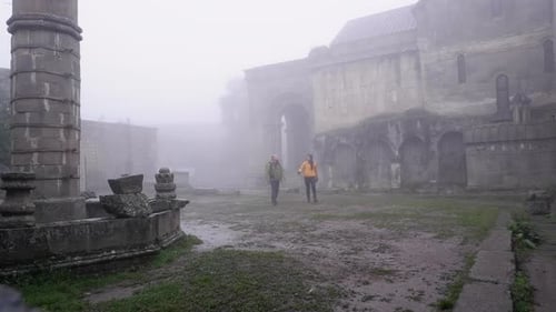 Un jeune couple profite de la solitude lors d'une journée humide et brumeuse au monastère de Tatev, en Arménie