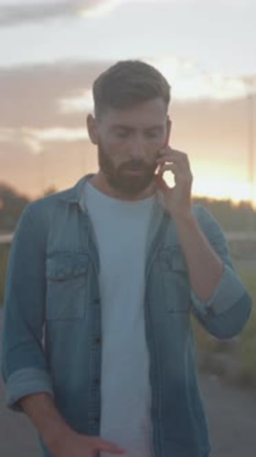 Individual Discusses Vehicle Issues at Dusk Man Explains Insurance or Tow Matters Under Golden