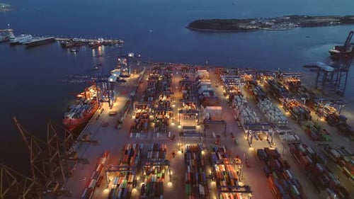 Luftaufnahme des Betriebs von industriellen Frachthäfen und Containerterminals zur Blauen Stunde