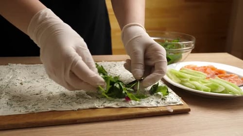 16. Greens are added to pita bread with cheese. Preparation of a roll with cheese, fish and vegetabl