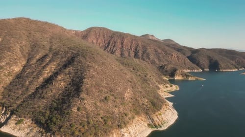Aerial drone flying over a lake, water dam, with mountains at sunrise. Beautifull dreamy landscape v