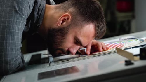 Worker Checking Print Quality of Graphics in Modern Printing House