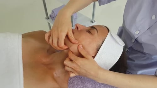 Woman Receives Relaxing Facial Massage at Spa