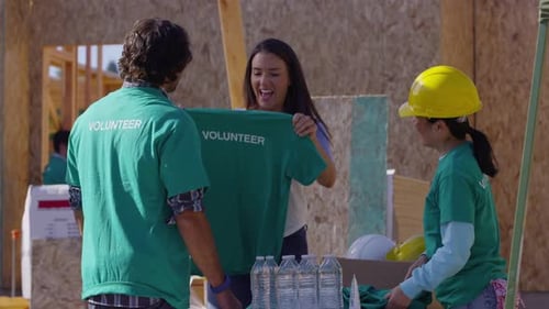 Volunteers Receive Hard Hats and Shirts at Construction Site