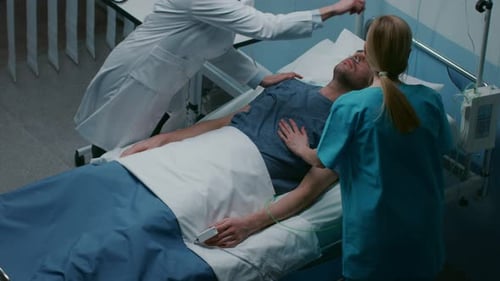 Emergency in the Hospital Doctor and Nurse Rush into the Ward to Safe Dying Patient. Man is Lying o